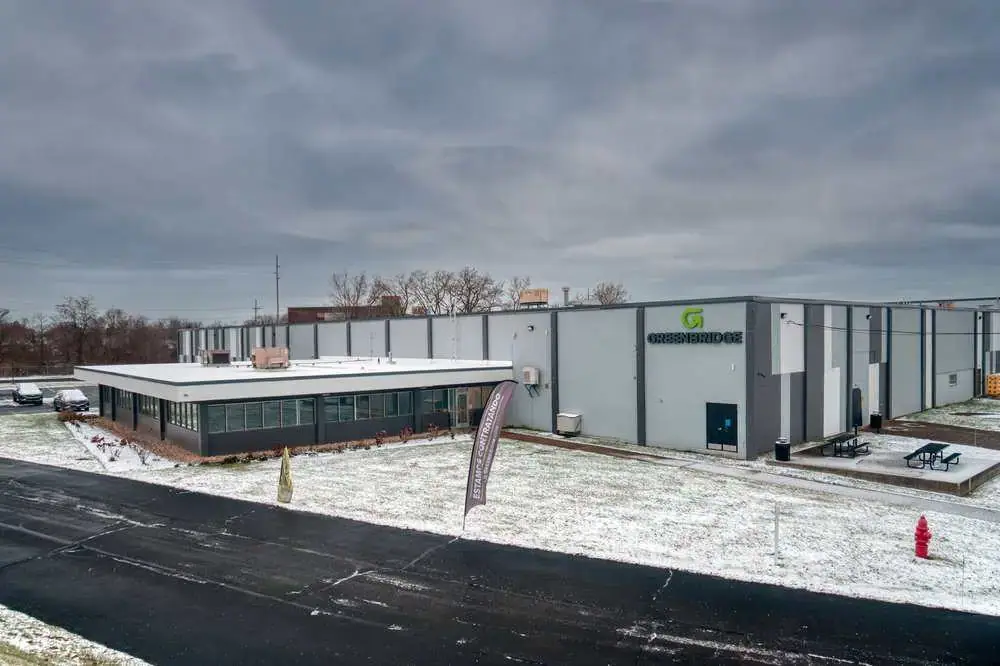 Aerial view of an industrial area with large warehouses surrounded by green trees, illustrating the proximity of nature to commercial spaces. Highlights potential areas for tree service and removal, relevant to Boulder Tree Service & Tree Removal Experts.